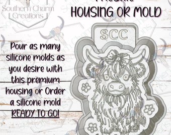 May include: A gray Highland cow freshie mold with the text "FRESHIE HOUSING OR MOLD" and "READY TO GO!". The mold has a detailed design of a cow with a bow and flowers. The text "Pour as many silicone molds as you desire with this premium housing or Order a silicone mold" is also visible.