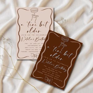 Könnte beinhalten: Zwei druckbare Geburtstagseinladungen mit braunem und rosafarbenem Hintergrund. Die Einladungen zeigen ein Weinglas mit einer Schleife am Stiel und den Text "a tiny bit older" und "Join us to celebrate Natalin's Birthday".