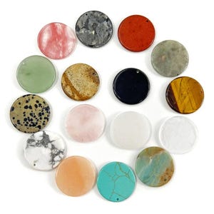 May include: A selection of sixteen circular gemstone pendants in diverse colours and patterns. The pendants feature pink, grey, red, green, brown, black, yellow, white, orange, and turquoise. Each pendant has a small hole for threading.
