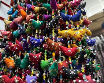 May include: A colorful garland of fabric birds with beaded accents. The birds are in various colors and patterns, including red, green, blue, yellow, and purple. The garland is perfect for adding a touch of whimsy to any space.
