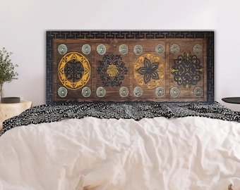May include: A wooden headboard with a carved design featuring four circular motifs in shades of yellow, green, and black. The headboard is framed with a dark brown border.