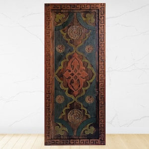 May include: A wooden door with a carved design in shades of brown, green, and red. The door has a decorative border with a repeating pattern.