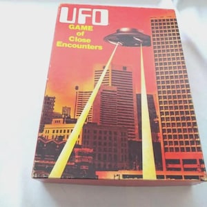 May include: A retro board game box with a red backdrop and a cityscape illustration. The box features a flying saucer with beams of light shining down on the city. The text on the box reads "UFO Game of Close Encounters."