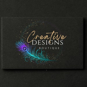 May include: A black and gold logo with the text "Creative Designs Boutique" in a white font. The logo features a peacock feather with blue, purple, and green colors.