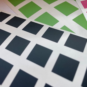 May include: A sheet of white paper with a grid of black squares. The squares are arranged in a diagonal pattern.