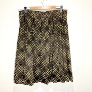 May include: A brown and beige patterned skirt with a pleated design. The skirt is made of a silky fabric and has a high waist.