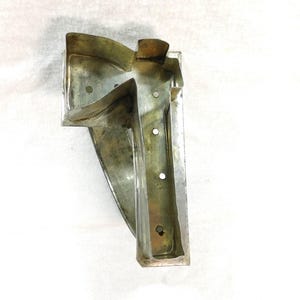 May include: A silver metal mold for baking a cake in the shape of a number seven. The mold has a smooth, shiny surface and is designed to create a detailed, three-dimensional number seven.