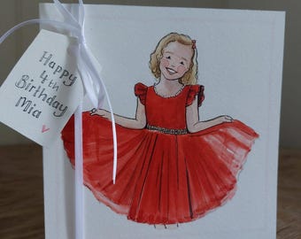 May include: A square white greeting card featuring a watercolor illustration of a smiling child with blonde hair wearing a red dress with ruffled sleeves. A white ribbon is tied around the card, holding a tag that reads Happy 4th Birthday Mia.