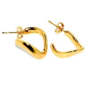 May include: A pair of gold-toned, open hoop earrings with a wavy, asymmetrical design.