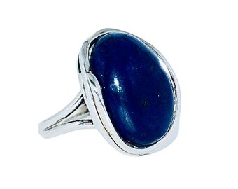 May include: A silver ring with a large, oval-shaped lapis lazuli gemstone. The stone is a deep blue color and has a smooth, polished finish.