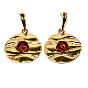 May include: A pair of gold earrings with a round, textured design. Each earring features a small, round amber stone in the centre.