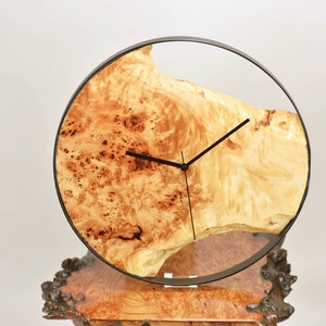 Hängande väggklocka i europeisk poppel, mappa burl, med metallkant, 38 cm i diameter. Klockan kan roteras till valfritt hängläge.