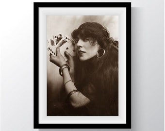 May include: A woman with long dark hair and a headscarf holds a deck of playing cards in her hand. She is wearing large hoop earrings and bracelets.