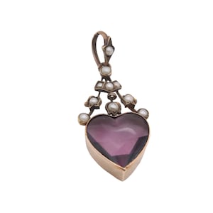 Puede incluir: Colgante vintage con una piedra de amatista en forma de coraz&oacute;n, engastada en un marco dorado. Adornado con peque&ntilde;as perlas redondas y una argolla decorativa. Dise&ntilde;o elegante y cl&aacute;sico, ideal para un collar. Joyer&iacute;a.