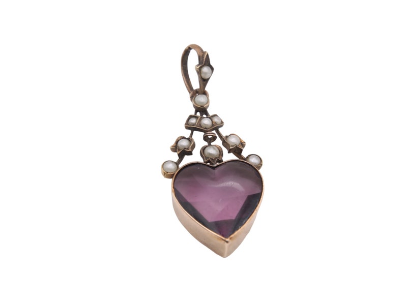 Puede incluir: Colgante vintage con una piedra de amatista en forma de coraz&oacute;n, engastada en un marco dorado. Adornado con peque&ntilde;as perlas redondas y una argolla decorativa. Dise&ntilde;o elegante y cl&aacute;sico, ideal para un collar. Joyer&iacute;a.
