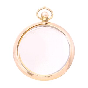 Op de afbeelding: Een goudkleurige, ronde hanger met een helder glazen midden. De hanger heeft een decoratieve lus aan de bovenkant met een kleine bal. Het ontwerp is eenvoudig en elegant, geschikt voor een ketting of bedel.