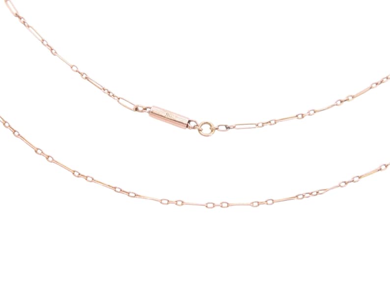 K&ouml;nnte beinhalten: Eine zarte Halskette aus Ros&eacute;gold mit feinem Kettendesign. Die Halskette hat eine Reihe kleiner, l&auml;nglicher Glieder, die durch winzige kreisf&ouml;rmige Ringe verbunden sind. Der Verschluss ist ein kleiner, rechteckiger Stab mit passendem Ros&eacute;gold-Finish.