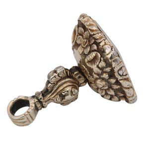 May include: A silver-toned antique wax seal with intricate floral and scrollwork details. The seal features a loop for hanging and a detailed design on the stamping surface, showcasing a vintage aesthetic.
