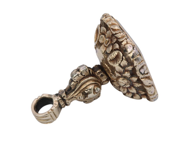 May include: A silver-toned antique wax seal with intricate floral and scrollwork details. The seal features a loop for hanging and a detailed design on the stamping surface, showcasing a vintage aesthetic.