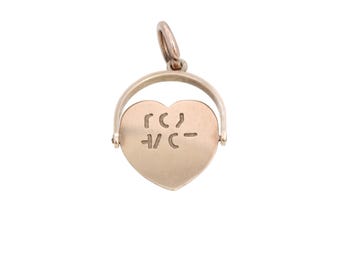May include: A gold-colored heart-shaped pendant with the word "LOVE" engraved on it. The pendant is attached to a circular bail, allowing it to be worn on a necklace or bracelet. The heart shape is a classic symbol of love and affection.