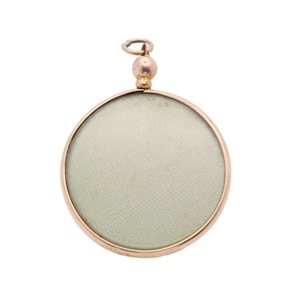 Op de afbeelding: Een ronde, goudkleurige hanger met een lichtgroen interieur. De hanger heeft een kleine lus voor een ketting en een decoratieve kraal. De lijst heeft een warme, metallic tint.