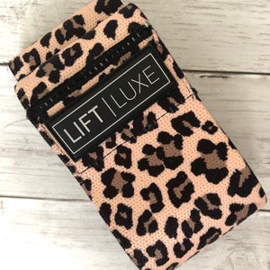 May include: Pink and black leopard print resistance band with a black label that says "LIFT LUXE".