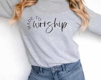 Puede incluir: Una sudadera gris con el texto "MADE TO WORSHIP" en letras negras.