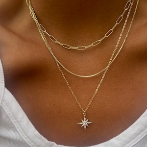 Three layer gold necklace set. Each chain is 14k and is durable and comes with a lobster clasp. The cable chain comes with a diamond north star charm. This necklace can be worn together or separately