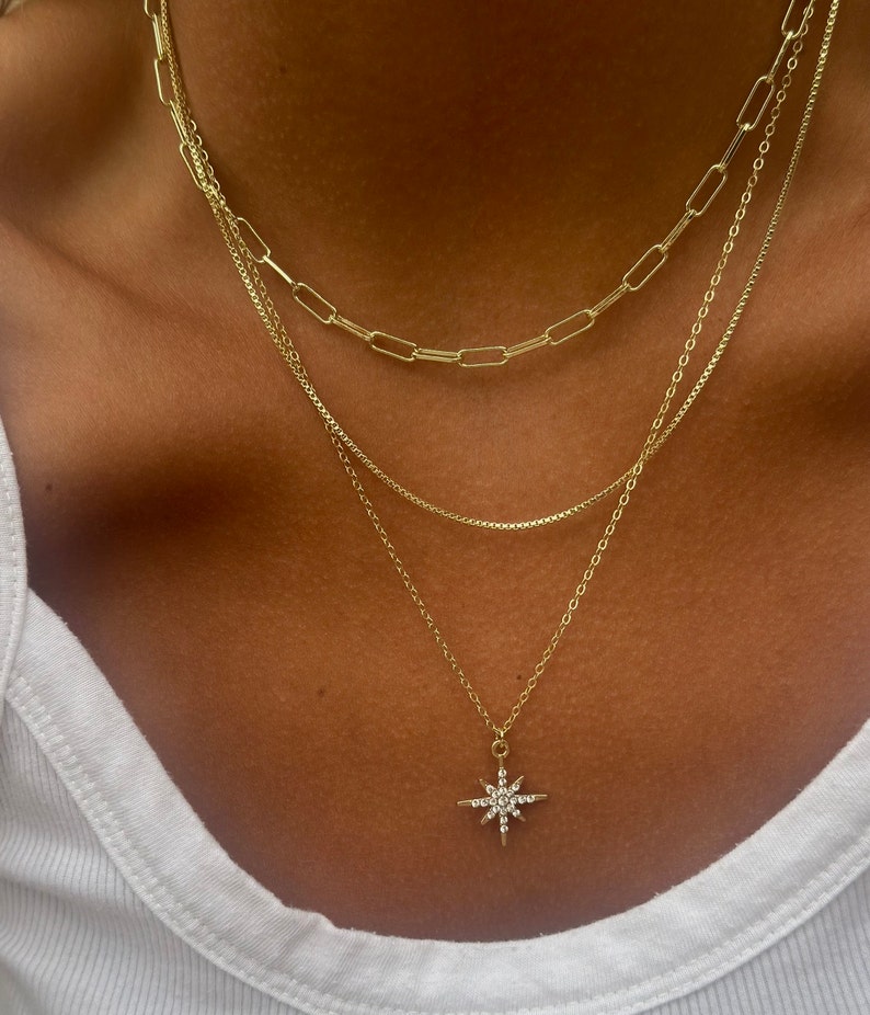 Three layer gold necklace set. Each chain is 14k and is durable and comes with a lobster clasp. The cable chain comes with a diamond north star charm. This necklace can be worn together or separately