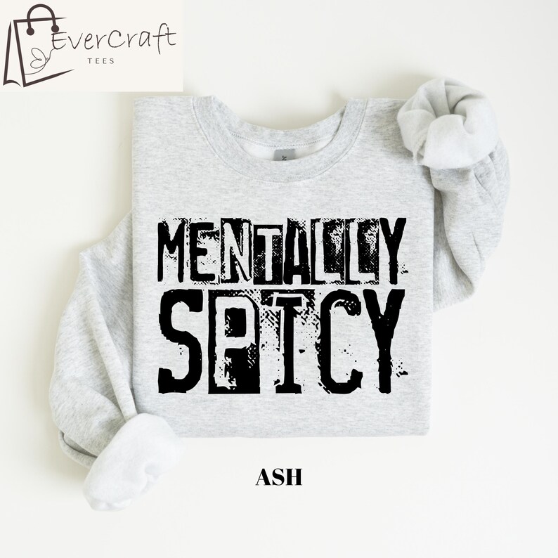Peut inclure: Sweat-shirt gris clair avec l'inscription noire "MENTALLY SPICY". Le mot "ASH" est imprim&eacute; en dessous. Le sweat-shirt a un col rond et des manches longues.