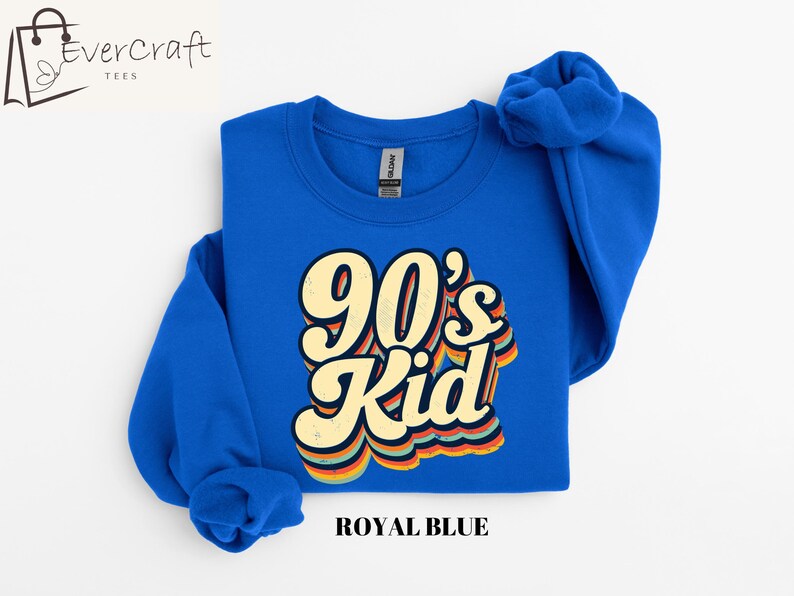 May include: A royal blue sweatshirt with the text "90's Kid" in a retro, rainbow-colored font.