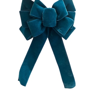 May include: A teal velvet bow with two long tails.