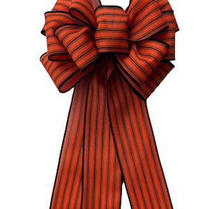 May include: A large orange and black striped bow with a black edge. The bow is made of fabric and has a long tail.