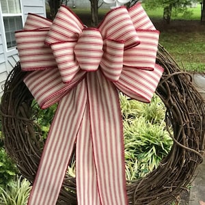 May include: A large red and white striped bow with a red edge, tied on a brown twig wreath.