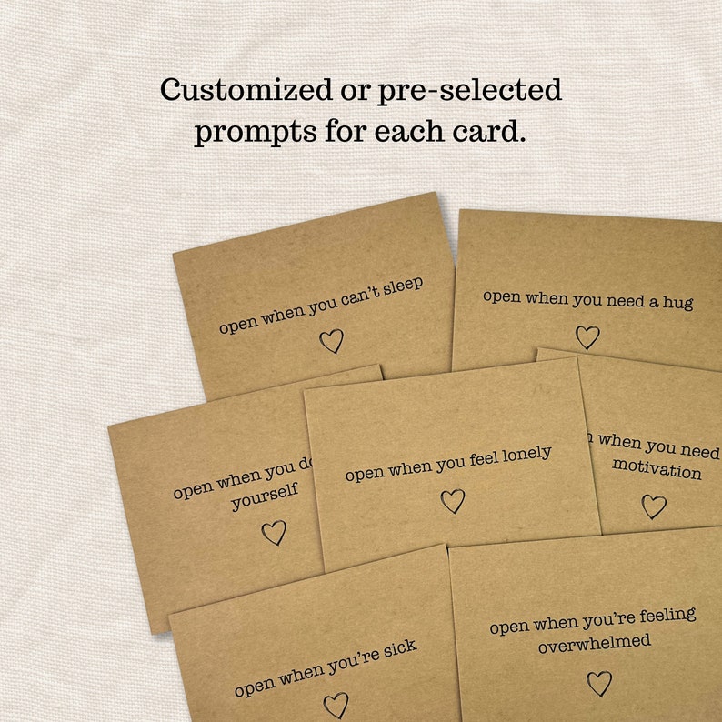 May include: A set of six brown cards with different prompts written on them. Each card has a small heart symbol at the bottom. The prompts are: "open when you can't sleep", "open when you need a hug", "open when you do yourself", "open when you feel lonely", "when you need motivation", "open when you're sick", and "open when you're feeling overwhelmed".