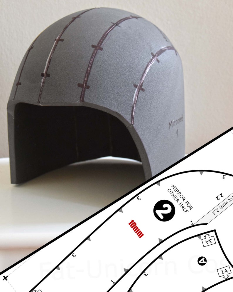 Op de afbeelding: Een grijs schuimrubberen helmdeel met donkerbruine getekende lijnen en markeringen, vergezeld van een wit papieren sjabloon met de tekst 10mm, MIRROR FOR OTHER HALF en het cijfer 2, samen met diverse montage-instructies en labels.