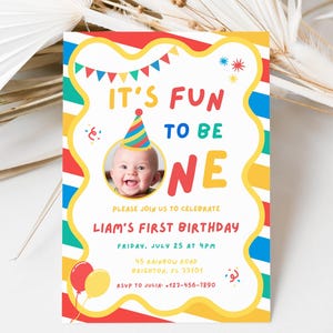 K&ouml;nnte beinhalten: Eine farbenfrohe Geburtstagseinladung mit dem Text "IT'S FUN TO BE ONE". Sie zeigt ein Foto eines Babys mit Partyhut. Die Einladung enth&auml;lt Details f&uuml;r Liams ersten Geburtstag, mit Luftballons und Konfetti.