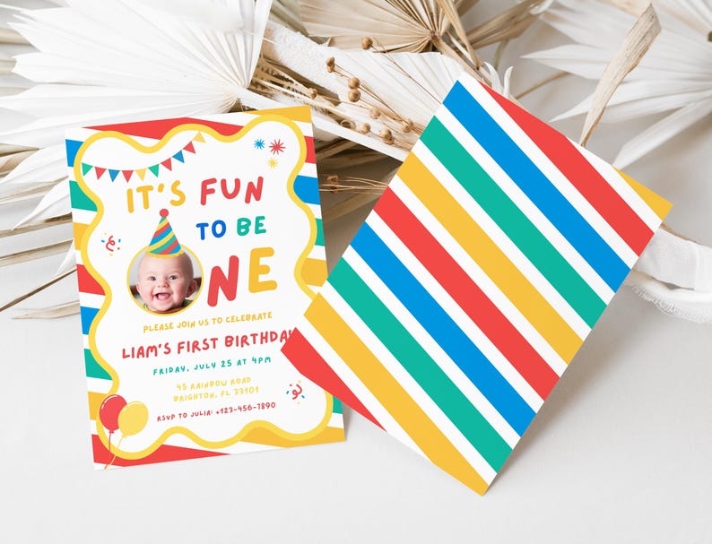 K&ouml;nnte beinhalten: Eine farbenfrohe Geburtstagseinladung mit dem Text "IT'S FUN TO BE ONE" und einem Foto eines Babys mit Partyhut. Die Einladung enth&auml;lt Veranstaltungsdetails. Eine Karte mit diagonalen Streifen in Rot, Gelb, Gr&uuml;n, Blau und Wei&szlig; ist ebenfalls vorhanden.