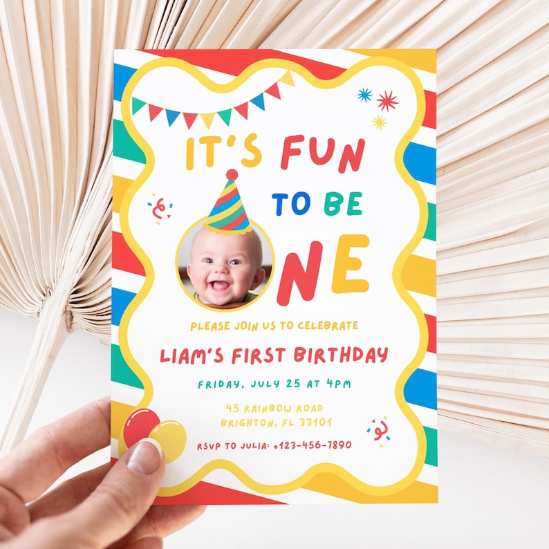 K&ouml;nnte beinhalten: Eine farbenfrohe Einladung zum ersten Geburtstag mit dem Text "IT'S FUN TO BE ONE." Die Einladung zeigt ein Foto eines l&auml;chelnden Babys mit Partyhut. Das Design umfasst rote, gelbe, blaue und gr&uuml;ne Akzente, mit dem Namen "Liam" und Party-Details.