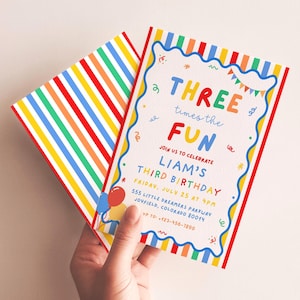 Könnte beinhalten: Eine rechteckige Geburtstagseinladungskarte mit einem regenbogenfarbenen Streifenrand und einem weißen Zentrum mit buntem Text: THREE times the FUN, JOIN US TO CELEBRATE LIAM'S THIRD BIRTHDAY, FRIDAY, JULY 25 AT 4PM, 555 LITTLE DREAMERS PARKWAY, JOYFIELD, COLORADO 80014, RSVP TO: +123-456-7890.