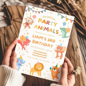 May include: A birthday party invitation with the text "Calling All Party Animals" and "Liam's 3rd Birthday." The invitation features colorful illustrations of cartoon animals, including a monkey, alligator, bear, elephant, lion, and tiger. The invitation is held by a person.