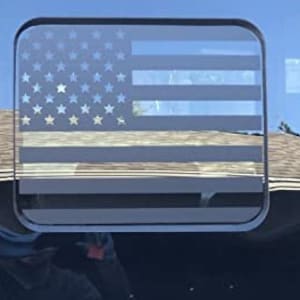 May include: A black and white American flag decal with a square outline. The decal is designed to be applied to a window or other smooth surface.