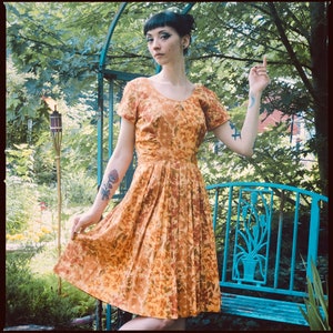 ダラスのブローガン＆ジェニングスによるテラコッタの花柄プリントの1950年代風フィット＆フレアドレス