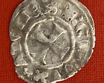May include: A silver coin with a cross in the center and a circular inscription around the edge. The coin is slightly worn and has a patina.