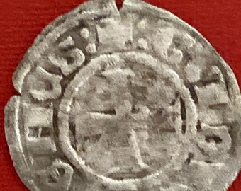 May include: A silver coin with a worn surface and a raised design. The coin has a circular shape with a raised rim around the edge. The design features a cross with a circle in the center. The coin has a worn, aged appearance.