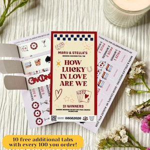 Könnte beinhalten: Eine rechteckige Hochzeits-Loskarte mit cremefarbenem Hintergrund und rotem sowie blauem Text mit der Aufschrift Maru & Stella's How Lucky In Love Are We. Die Karte zeigt Illustrationen von Würfeln, einem Herz, Sternen und Spielkarten.