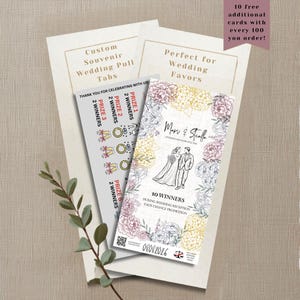 Op de afbeelding: Rechthoekige trouwkaarten met treklipjes, voorzien van een lijntekening van een bruidspaar, bloemrijke randen in roze en geel, en tekst zoals Mari & Stella, 10 Winners en 08082026. De kaarten tonen prijscategorieën en een QR-code.