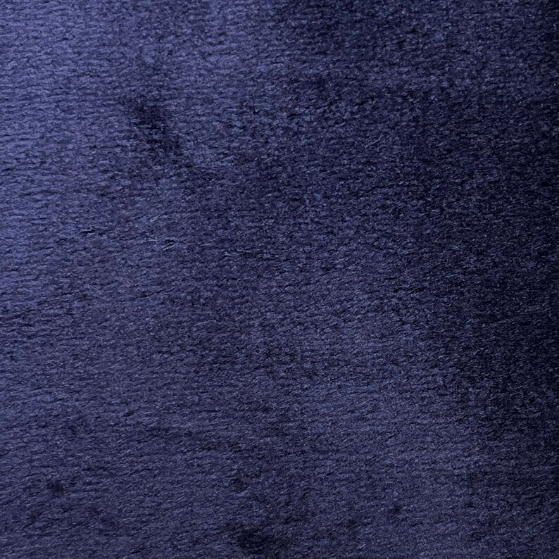 May include: A close-up of a dark blue fabric with a textured surface.