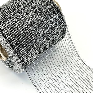 May include: A roll of silver and black metallic mesh ribbon. The ribbon is a fine, open weave and has a shiny finish.