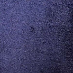 May include: A close-up of a dark blue textured fabric. The fabric has a slightly fuzzy surface.